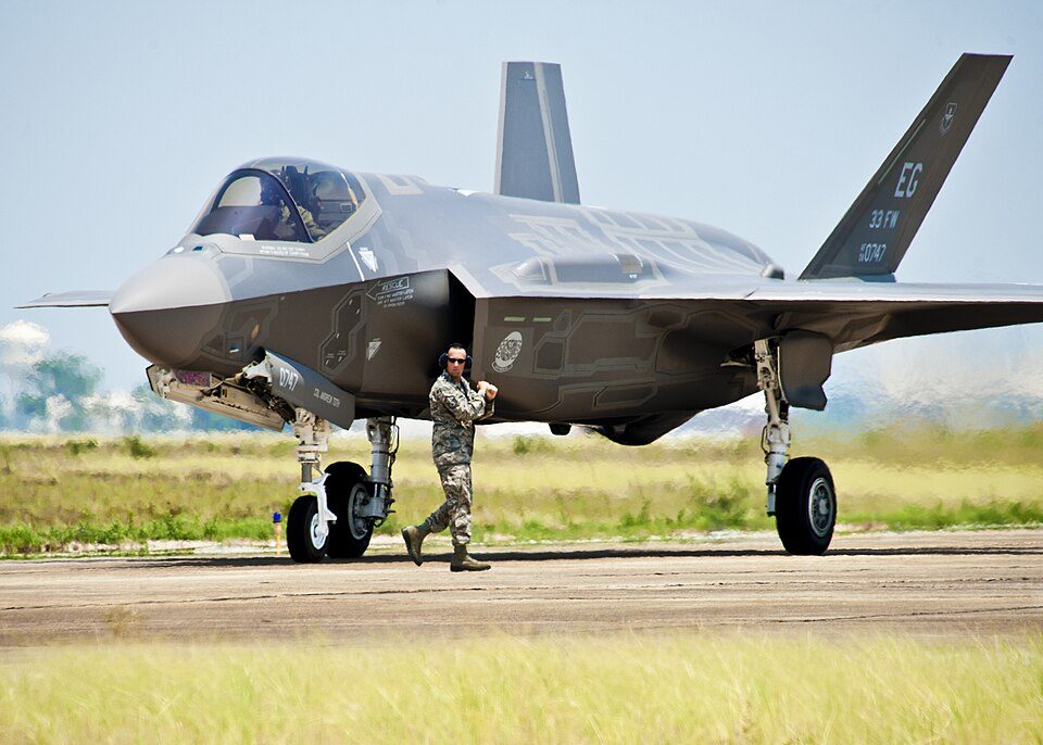 A 33rd Fighter Wing aircraft maintainer moves by the Department of Defense's newest aircraft, the U.S. Air Force F-35 Lightning II joint str
